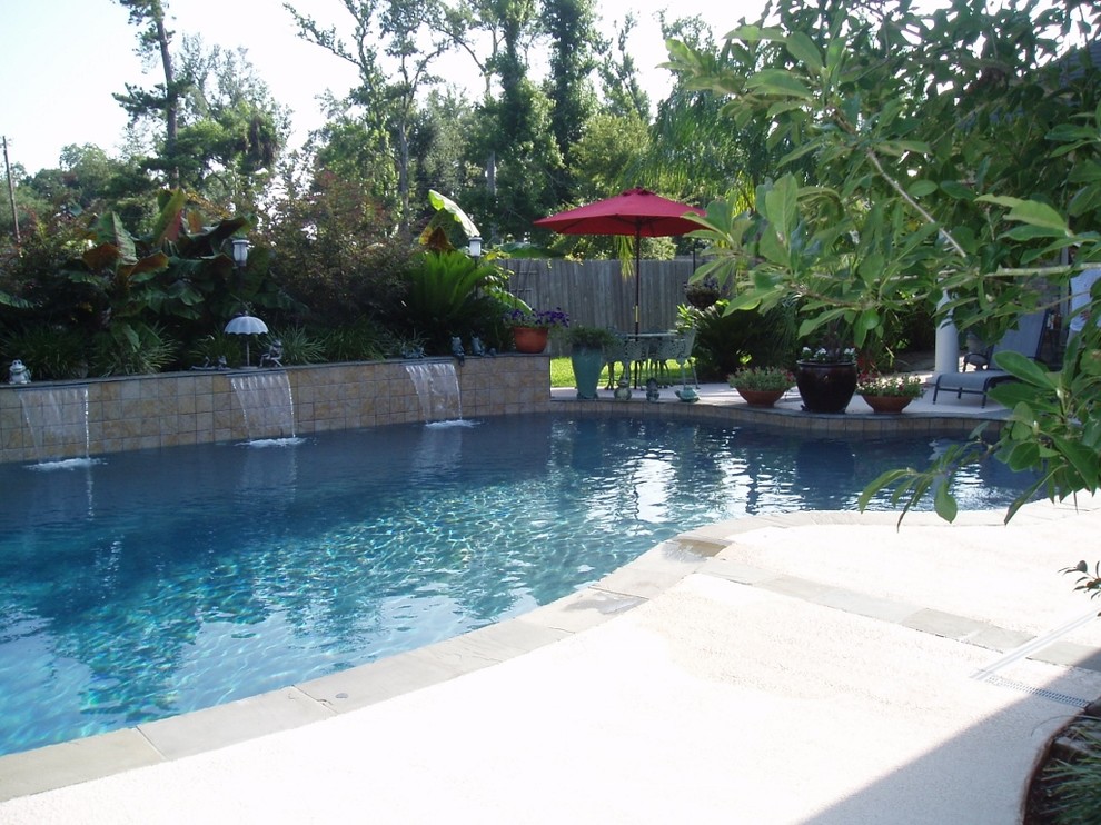 Ejemplo de piscina con fuente contemporánea a medida en patio trasero