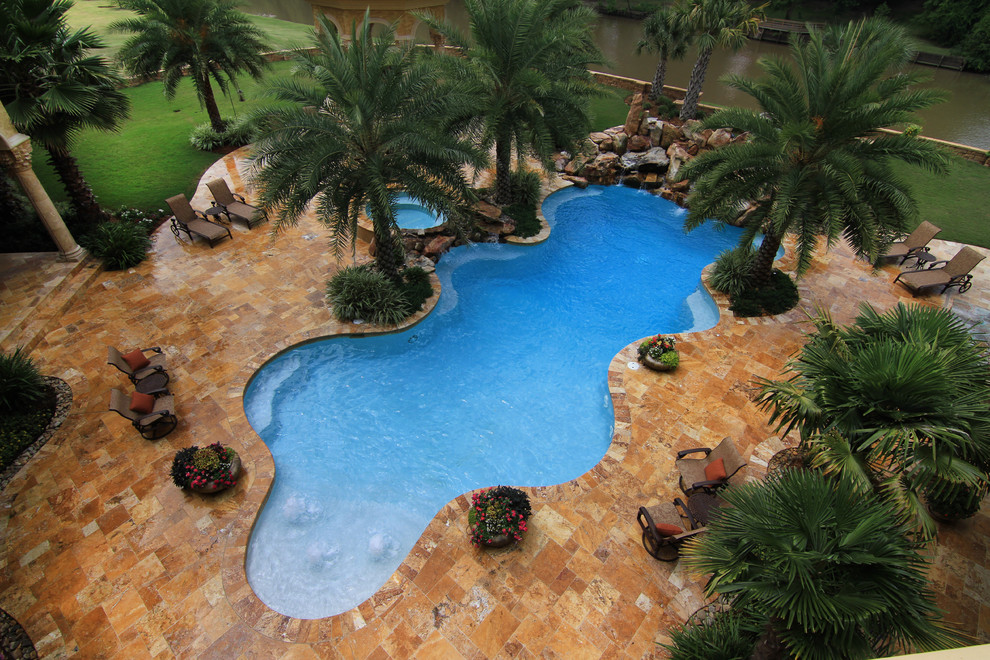 На фото: бассейн произвольной формы на заднем дворе в морском стиле с фонтаном с