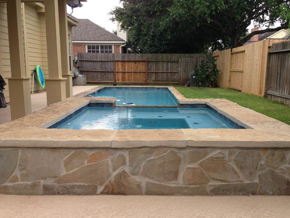Modelo de piscinas y jacuzzis naturales de estilo americano pequeños rectangulares en patio trasero con losas de hormigón