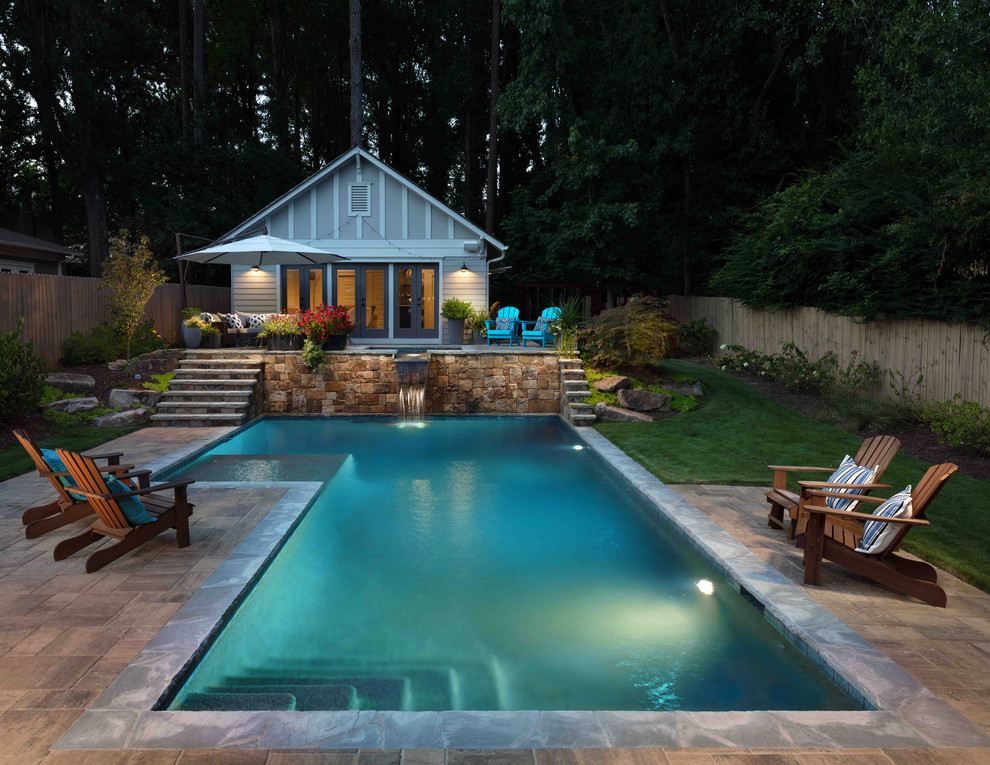 Modelo de piscinas y jacuzzis tradicionales renovados grandes en forma de L en patio trasero con adoquines de piedra natural