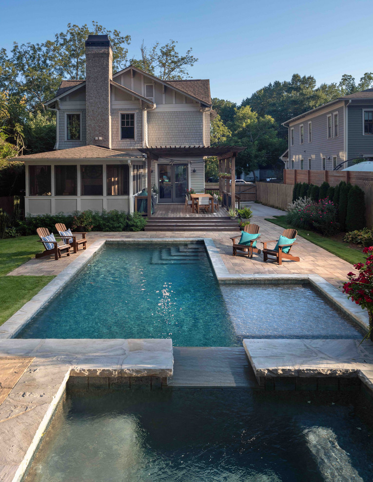 Modelo de piscinas y jacuzzis naturales clásicos renovados grandes en forma de L en patio trasero con adoquines de piedra natural
