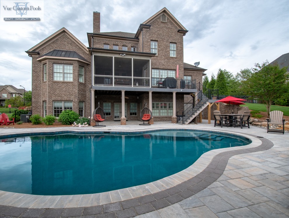 Modelo de casa de la piscina y piscina natural de estilo americano de tamaño medio a medida en patio trasero con adoquines de hormigón