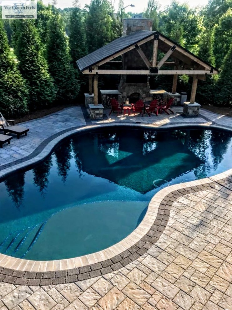 Modelo de casa de la piscina y piscina natural de estilo americano de tamaño medio a medida en patio trasero con adoquines de hormigón