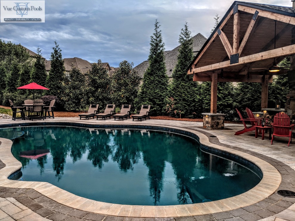 Ispirazione per una piscina naturale american style personalizzata di medie dimensioni e dietro casa con una dépendance a bordo piscina e pavimentazioni in cemento