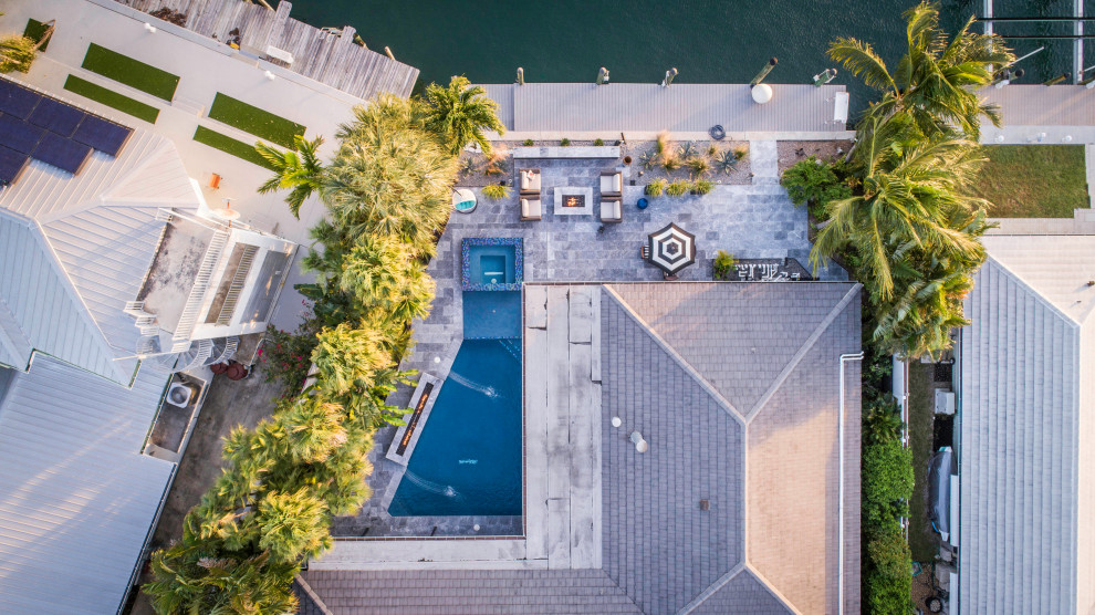 Pool fountain - large backyard custom-shaped lap pool fountain idea in Miami