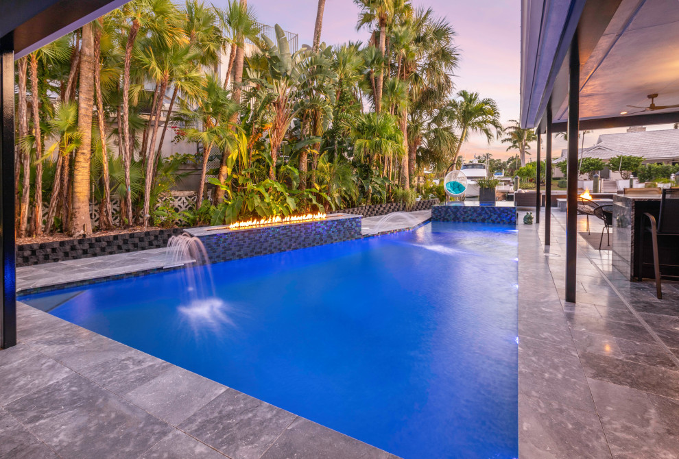Foto de piscina con fuente alargada moderna grande a medida en patio trasero