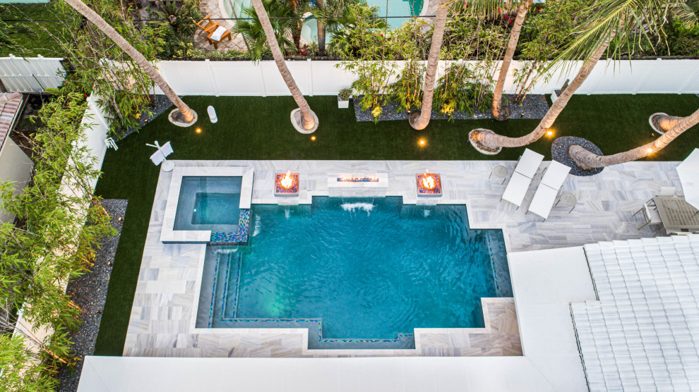 Immagine di una piscina minimalista personalizzata di medie dimensioni e dietro casa con fontane