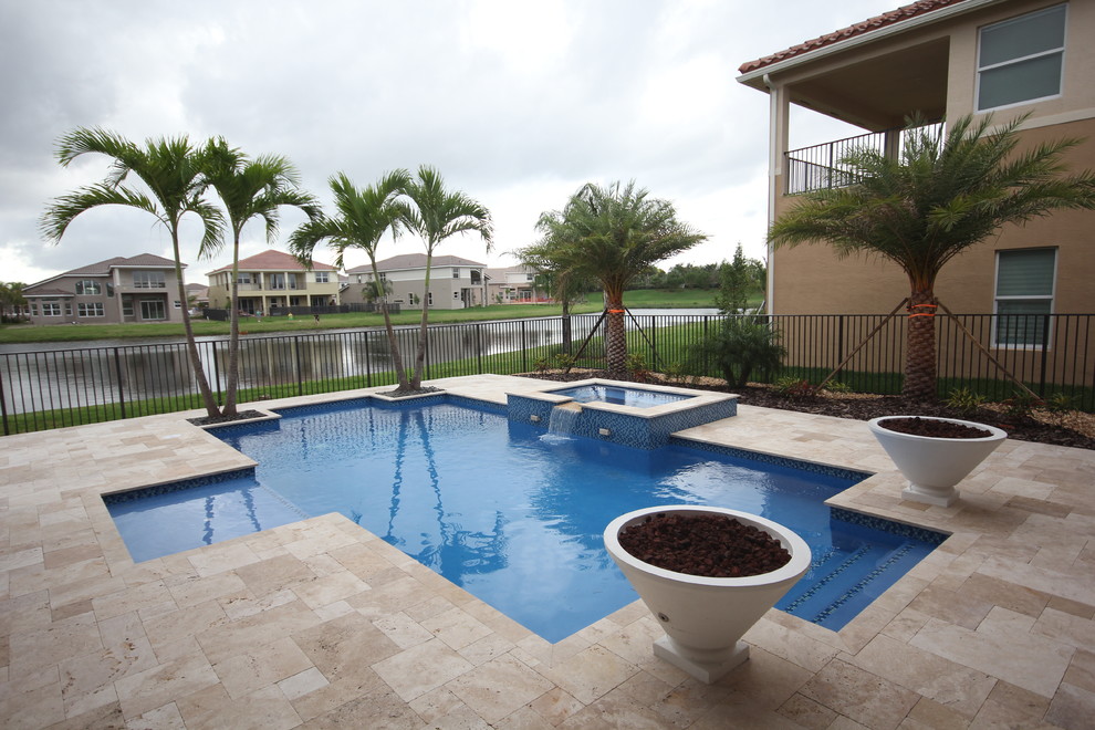 Großer Whirlpool hinter dem Haus in rechteckiger Form mit Natursteinplatten in Miami