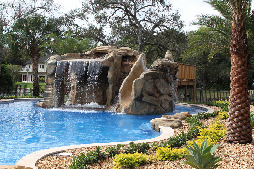 Foto di un'ampia piscina stile marinaro personalizzata dietro casa con fontane e pavimentazioni in pietra naturale