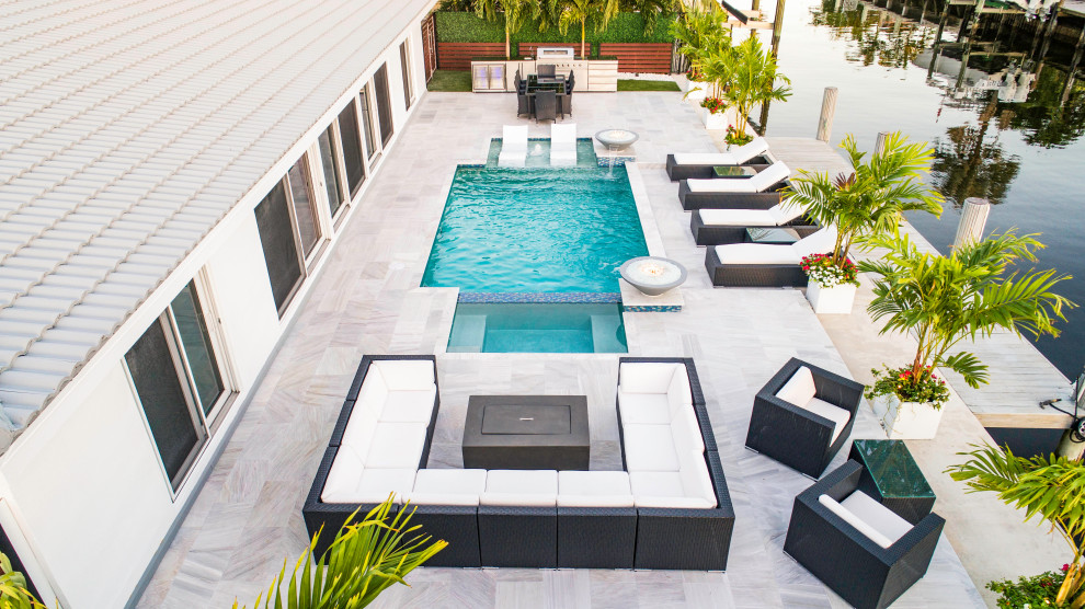 Modelo de piscina con fuente alargada minimalista de tamaño medio rectangular en patio trasero
