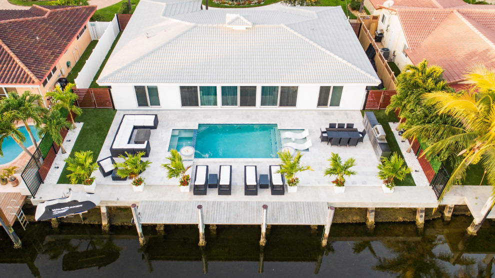 Mittelgroßes Modernes Sportbecken hinter dem Haus in rechteckiger Form mit Wasserspiel in Miami