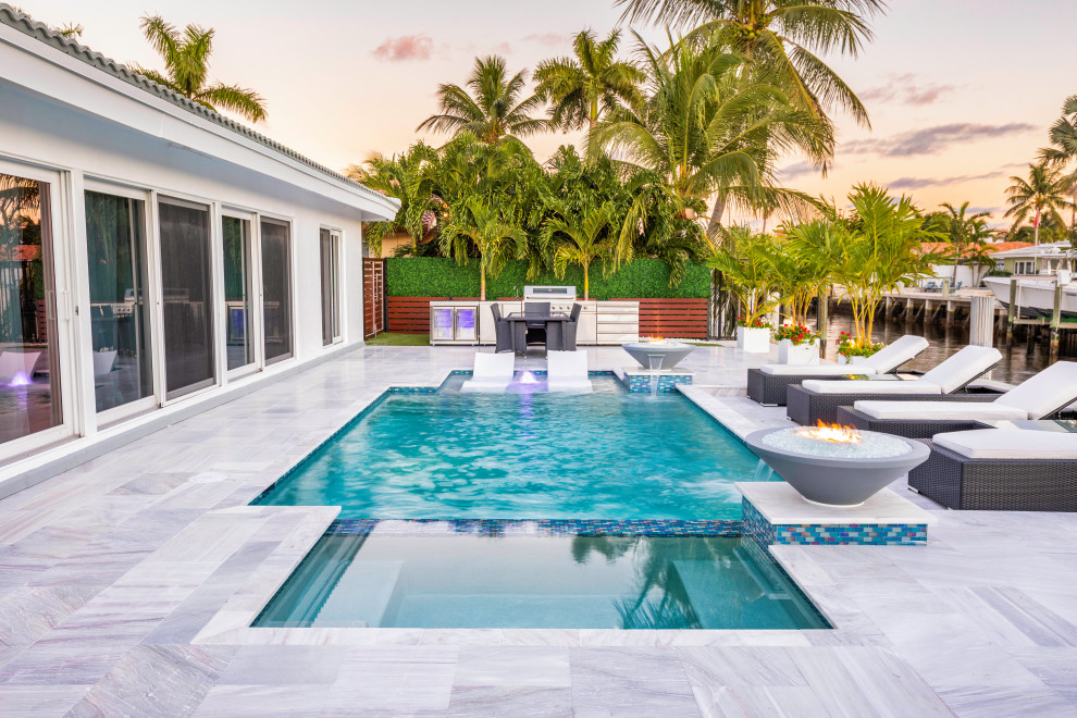 Imagen de piscina con fuente alargada moderna de tamaño medio rectangular en patio trasero
