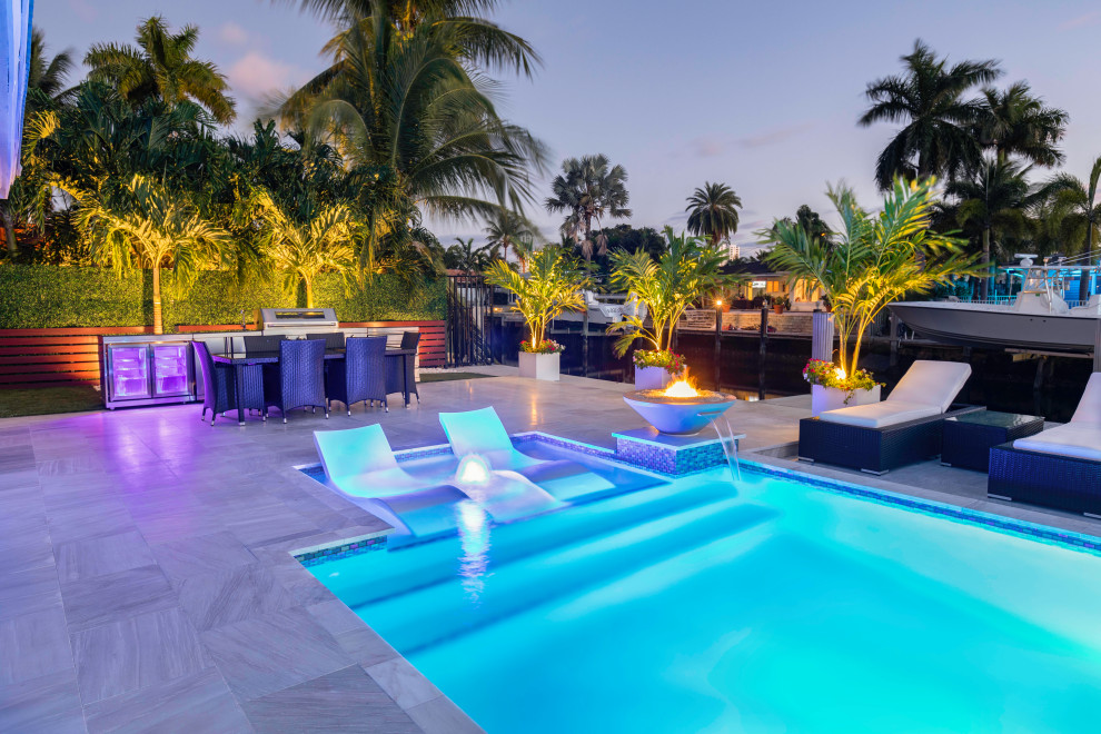 Mittelgroßes Modernes Sportbecken hinter dem Haus in rechteckiger Form mit Wasserspiel in Miami