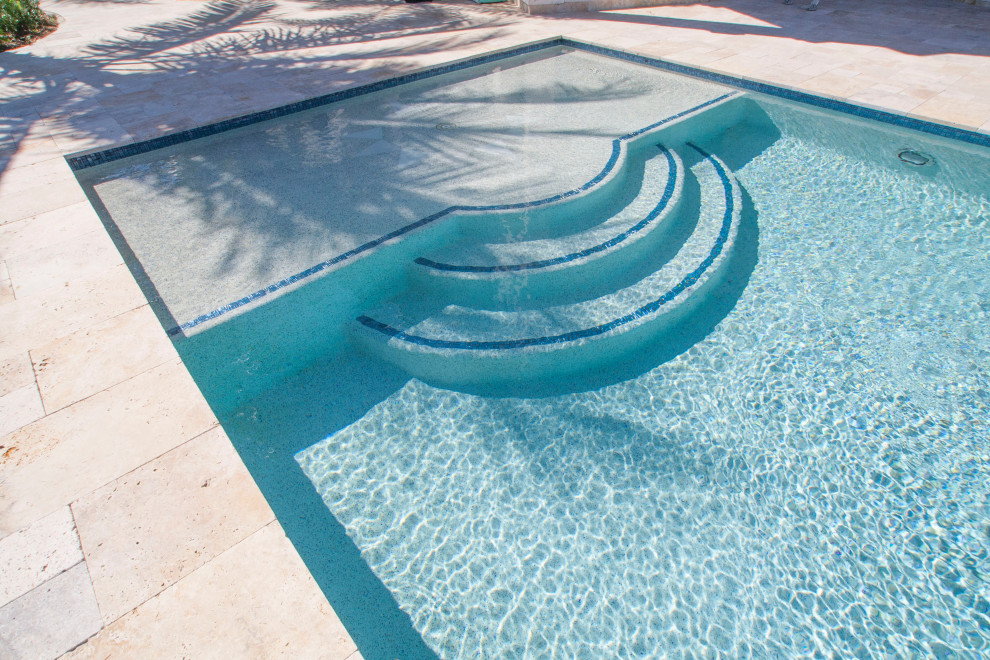 Foto di una piscina monocorsia tropicale personalizzata di medie dimensioni e dietro casa con una vasca idromassaggio e pavimentazioni in pietra naturale