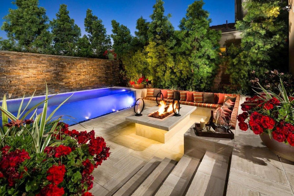 Mittelgroßer, Gefliester Infinity-Pool hinter dem Haus in rechteckiger Form mit Wasserspiel in Orange County