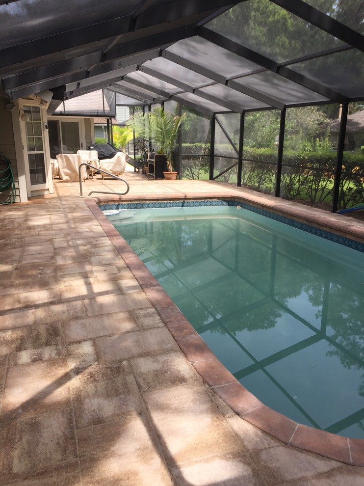 Ejemplo de casa de la piscina y piscina alargada clásica renovada de tamaño medio rectangular en patio trasero con suelo de hormigón estampado