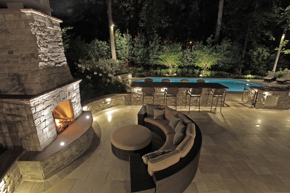 Immagine di un'ampia piscina classica personalizzata dietro casa con piastrelle
