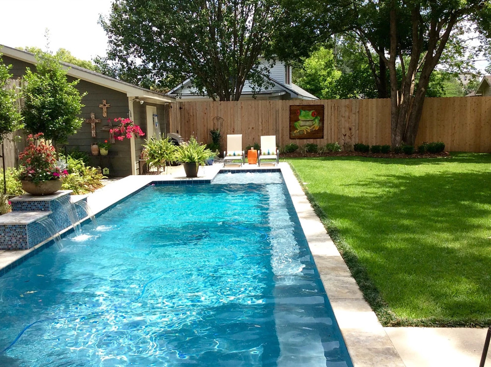 Diseño de piscina con fuente alargada tradicional de tamaño medio en forma de L en patio trasero con adoquines de hormigón