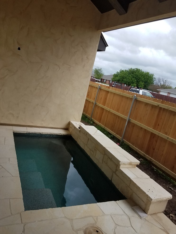 Esempio di una piccola piscina monocorsia classica rettangolare dietro casa con pavimentazioni in pietra naturale
