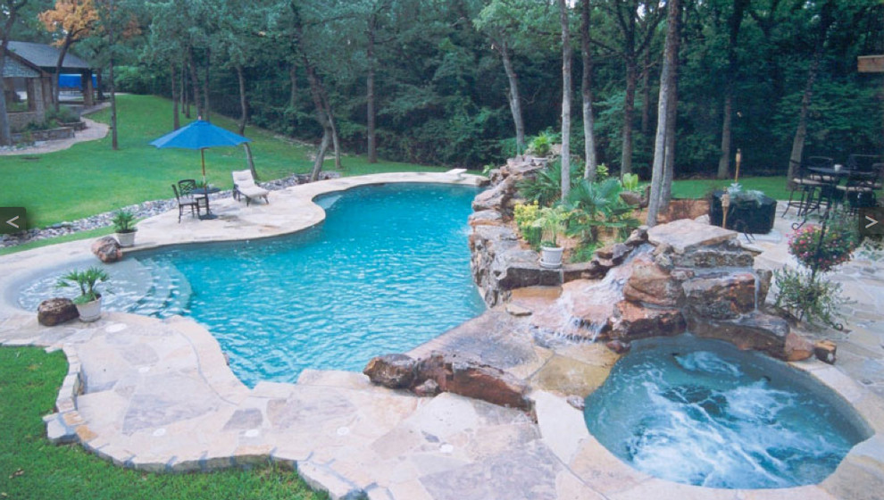 Example of an island style backyard stone and custom-shaped pool design in Dallas