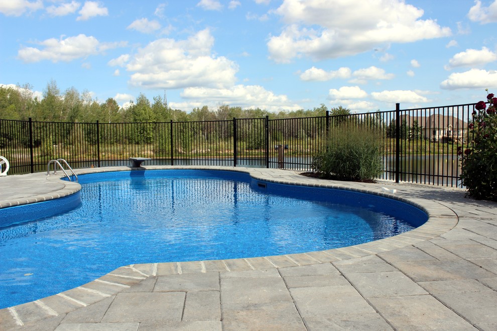 Idee per una grande piscina monocorsia stile marinaro dietro casa con fontane e cemento stampato