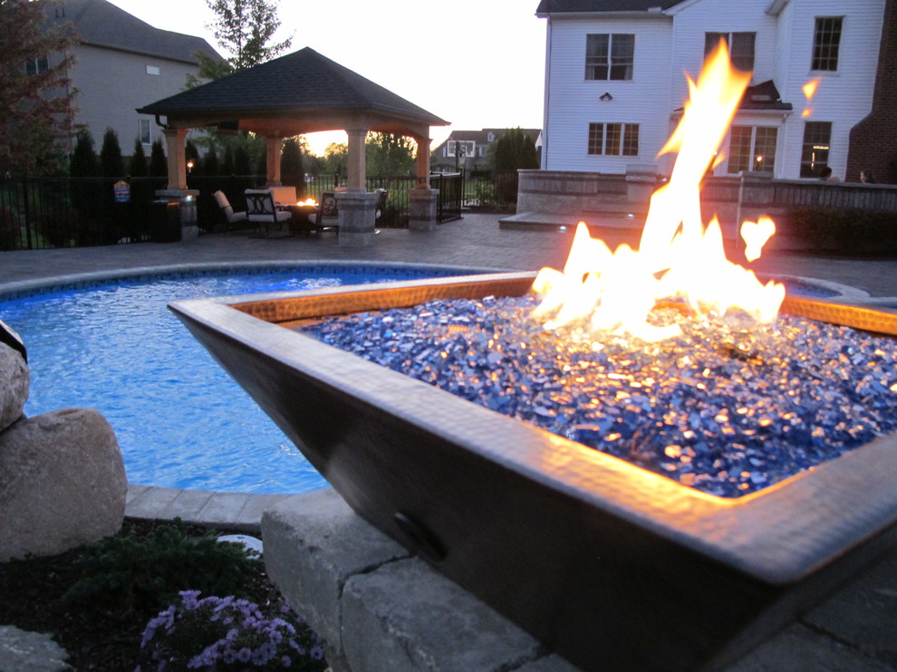 Example of a transitional backyard brick and custom-shaped hot tub design in Detroit