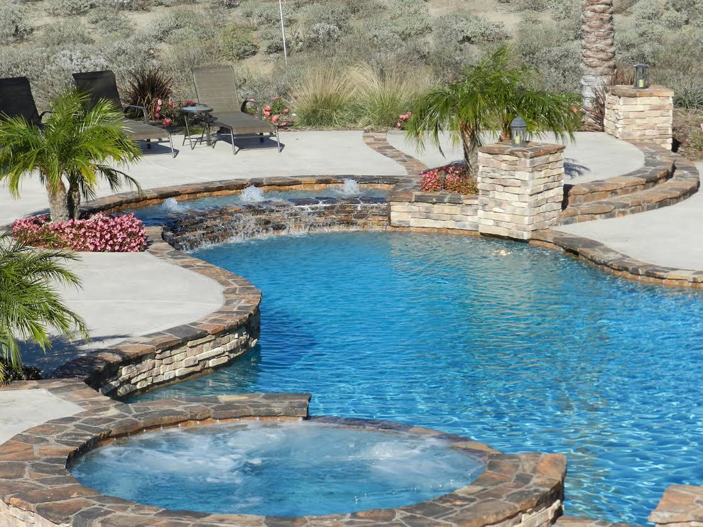 Foto di una piscina tradizionale personalizzata di medie dimensioni e dietro casa con una vasca idromassaggio e pavimentazioni in cemento