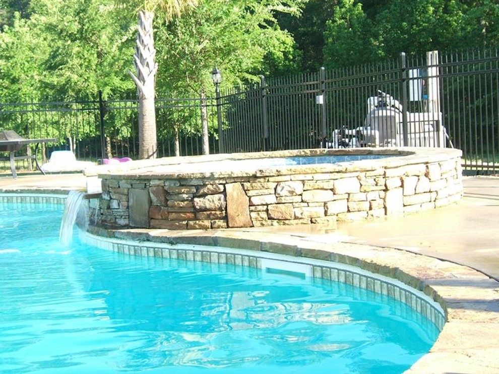 Пример оригинального дизайна: бассейн среднего размера, произвольной формы на заднем дворе в классическом стиле с джакузи и покрытием из бетонных плит