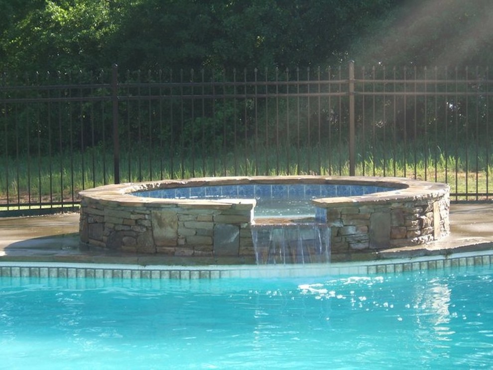 Imagen de piscinas y jacuzzis clásicos de tamaño medio a medida en patio trasero con losas de hormigón