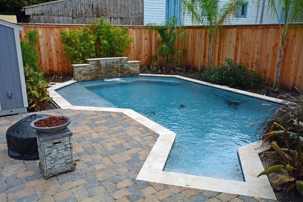 Modelo de piscina con fuente actual de tamaño medio a medida en patio trasero con adoquines de ladrillo