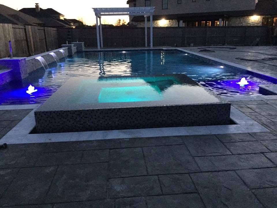 Ispirazione per una grande piscina minimalista personalizzata dietro casa con cemento stampato e una vasca idromassaggio