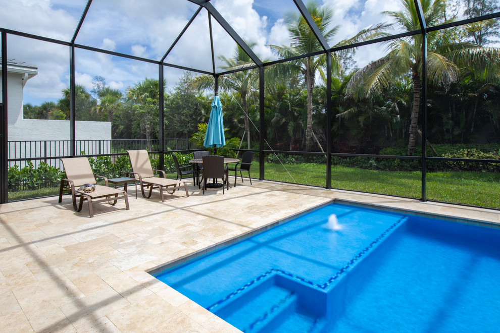 Großer Moderner Pool hinter dem Haus in rechteckiger Form mit Wasserspiel und Natursteinplatten in Miami