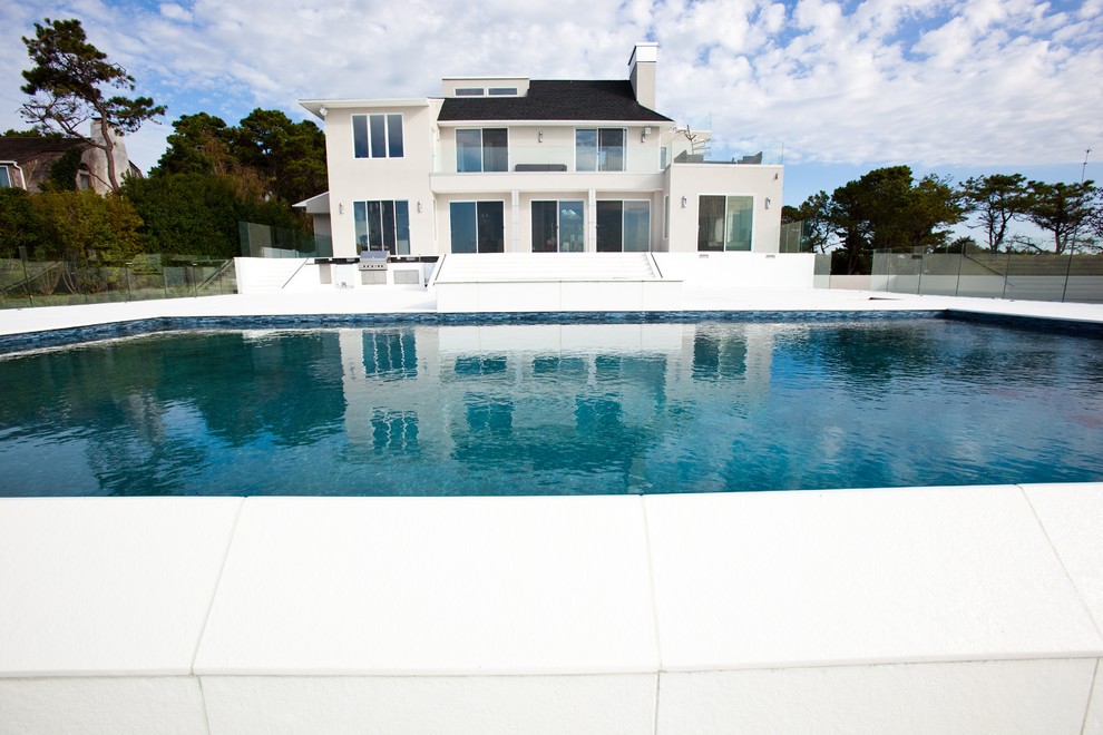 Geräumiger, Gefliester Moderner Infinity-Pool hinter dem Haus in rechteckiger Form mit Wasserspiel in New York