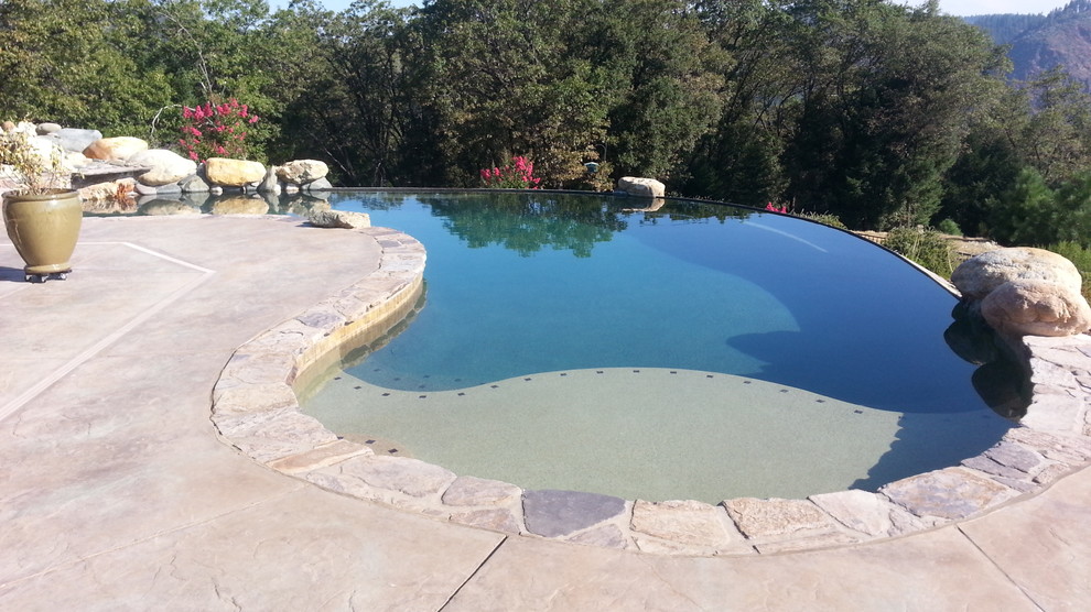 Cette image montre une piscine arrière sud-ouest américain sur mesure avec une dalle de béton.