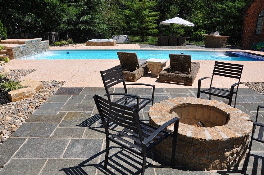Foto de piscina con fuente contemporánea de tamaño medio rectangular en patio trasero con losas de hormigón