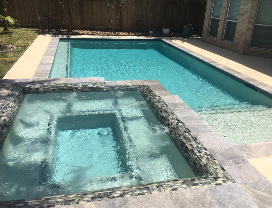 Foto di una piscina chic rettangolare di medie dimensioni e dietro casa con una vasca idromassaggio e lastre di cemento