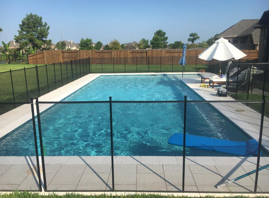 Immagine di una grande piscina naturale chic rettangolare dietro casa con pavimentazioni in cemento