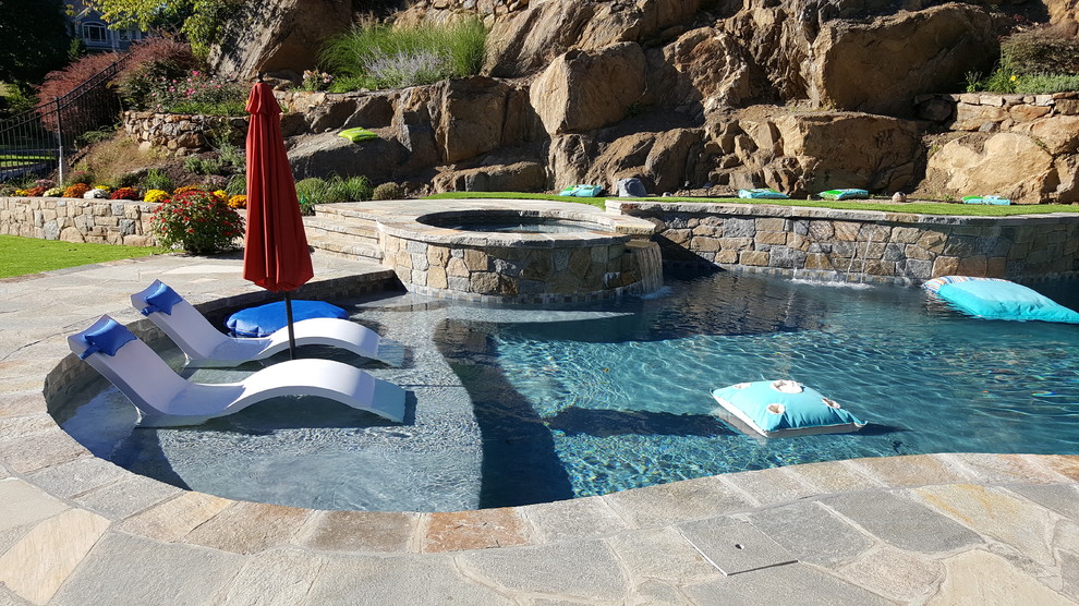 Medium sized classic back custom shaped lengths hot tub in New York with natural stone paving.