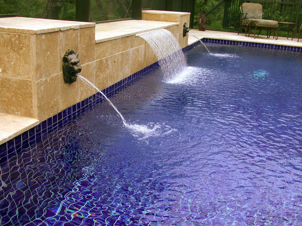 Ispirazione per una piscina design rettangolare di medie dimensioni e dietro casa con fontane