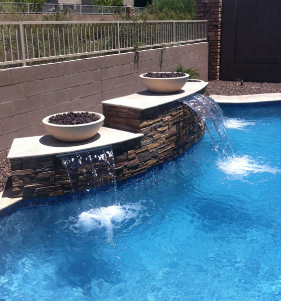 Diseño de piscina con fuente clásica de tamaño medio a medida en patio trasero con gravilla