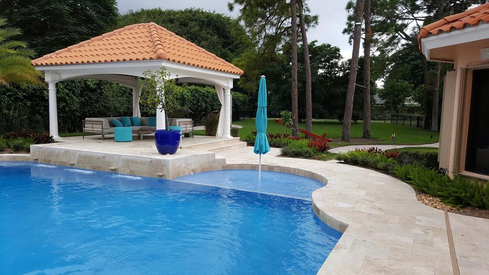 Imagen de piscina con fuente alargada clásica grande rectangular en patio trasero con adoquines de piedra natural