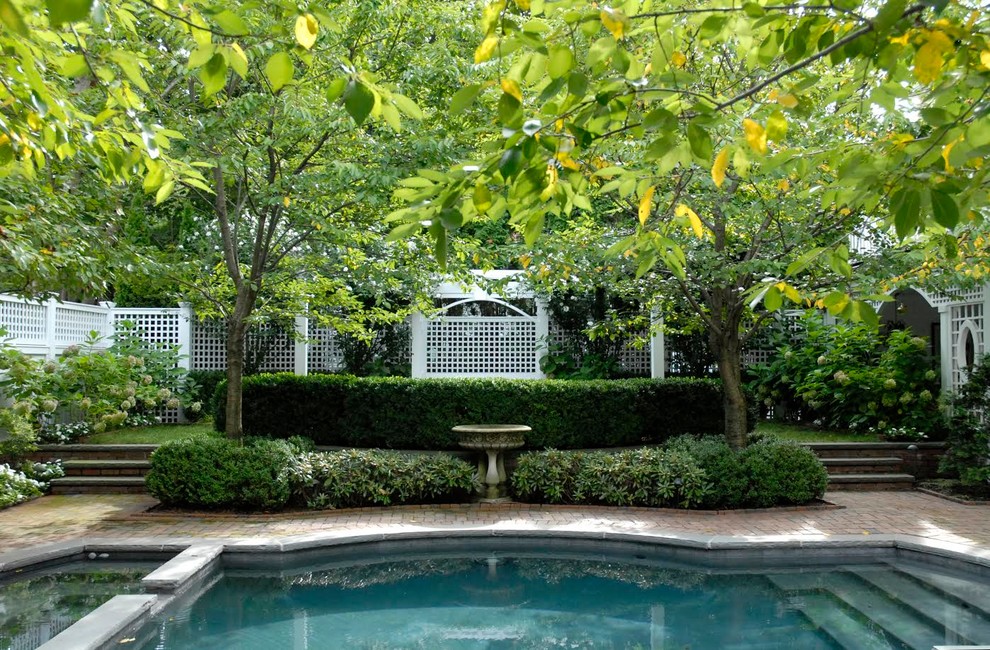 Immagine di una grande piscina monocorsia classica rettangolare dietro casa con una vasca idromassaggio e pavimentazioni in mattoni