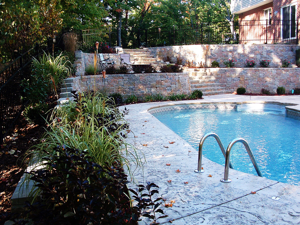 Diseño de piscina rústica de tamaño medio a medida en patio trasero con adoquines de hormigón
