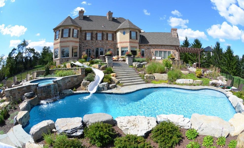Large trendy backyard stone and custom-shaped water slide photo in Philadelphia