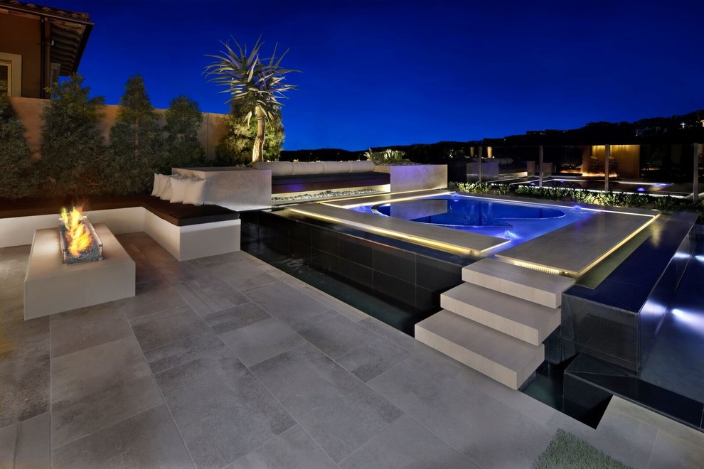 Ispirazione per una piccola piscina a sfioro infinito moderna personalizzata dietro casa con una vasca idromassaggio