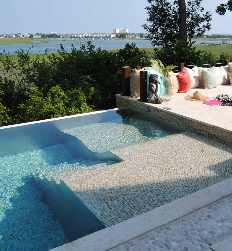 Ispirazione per una grande piscina a sfioro infinito design dietro casa con una vasca idromassaggio e piastrelle
