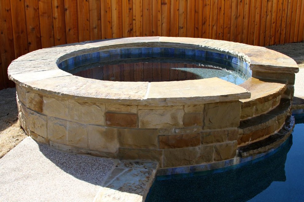 Diseño de piscinas y jacuzzis naturales tradicionales grandes redondeados en patio trasero con granito descompuesto