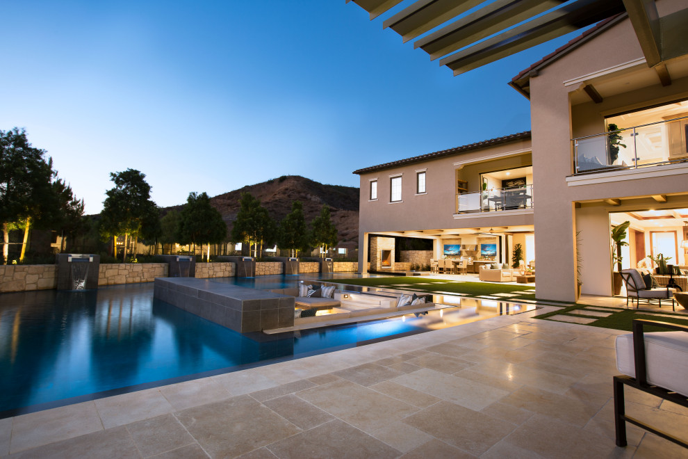 Foto de piscina con fuente infinita moderna extra grande a medida en patio trasero con adoquines de piedra natural