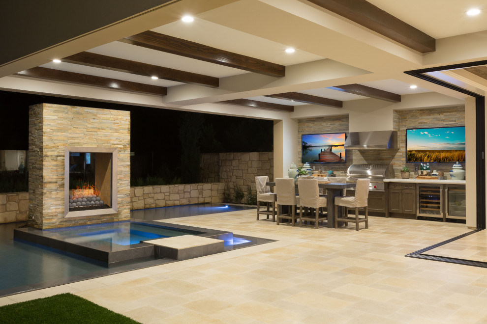 Inspiration for a huge modern backyard stone and custom-shaped infinity hot tub remodel in Orange County
