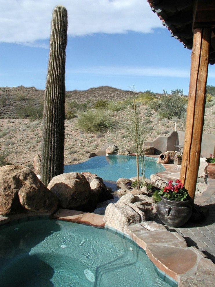 Mittelgroßer Moderner Infinity-Pool hinter dem Haus in individueller Form mit Wasserspiel und Betonboden in Phoenix